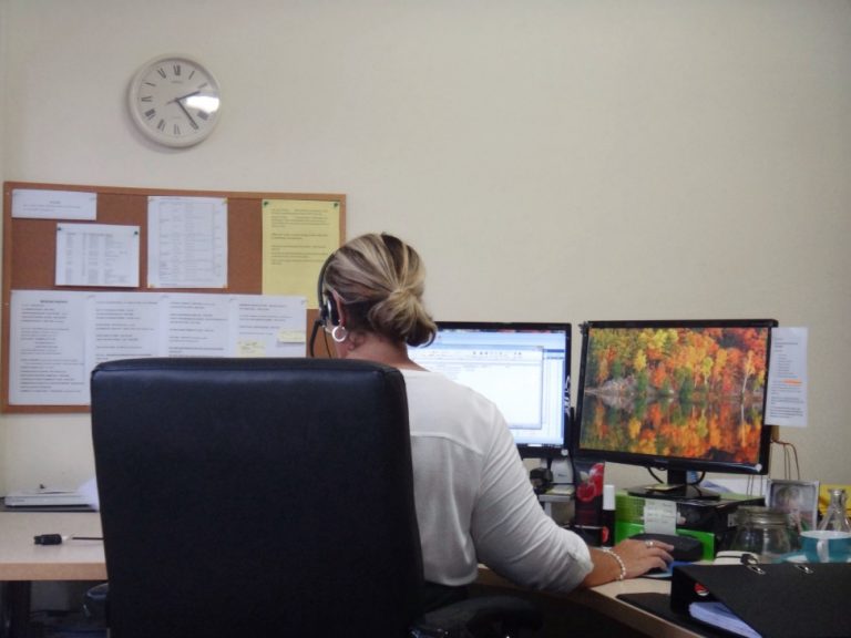 controle de horas extras - mulher sentada em sua cadeira de escritório trabalhando